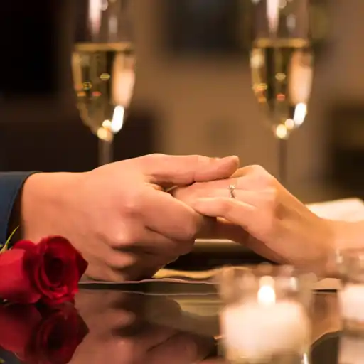 Couple holding hands over a meal for Valentines Day